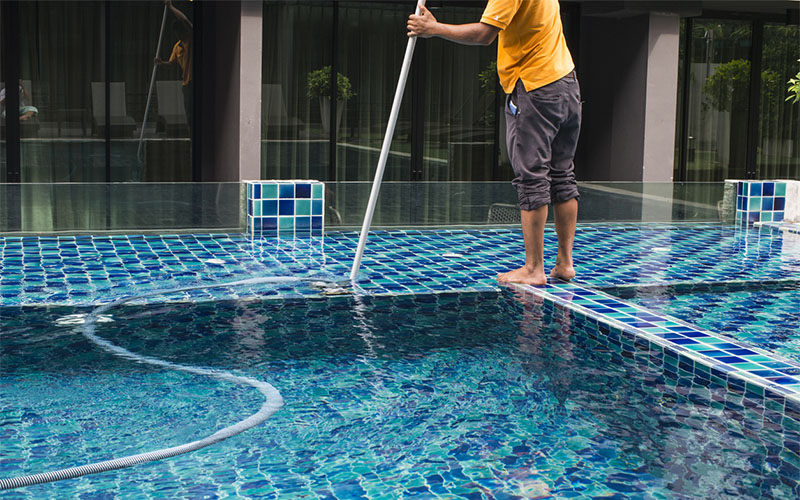 A man cleaning the swimming pool